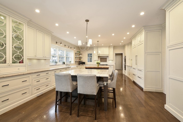 dining room featuring a notable chandelier, ornamental molding, dark wood-style flooring, and recessed lighting