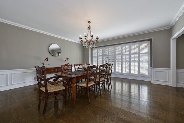 dining area with crown molding, dark wood finished floors, a decorative wall, and an inviting chandelier