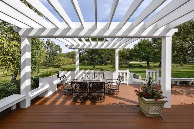 deck with outdoor dining space, a yard, and a pergola