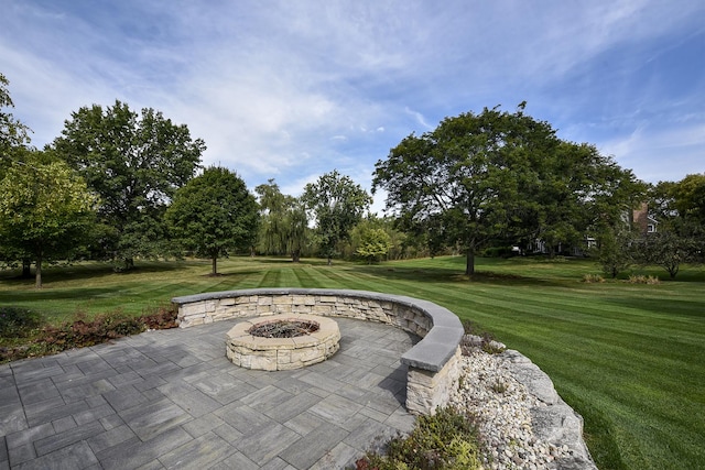 view of home's community featuring a patio area, an outdoor fire pit, and a yard