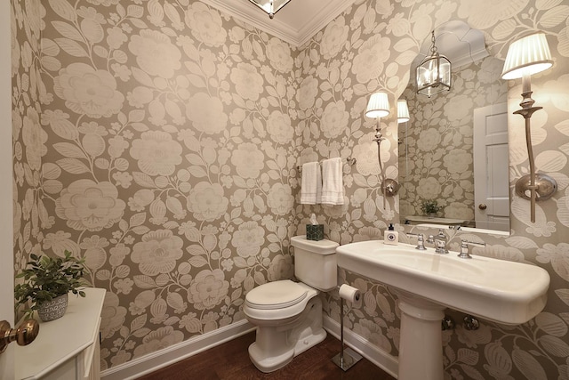 half bathroom featuring baseboards, crown molding, toilet, and wood finished floors