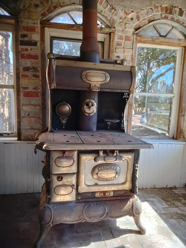 interior details featuring a wood stove and wainscoting