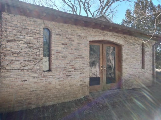 property entrance featuring french doors and brick siding