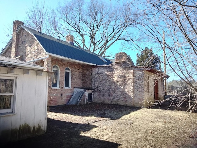 view of property exterior featuring a chimney and a shingled roof