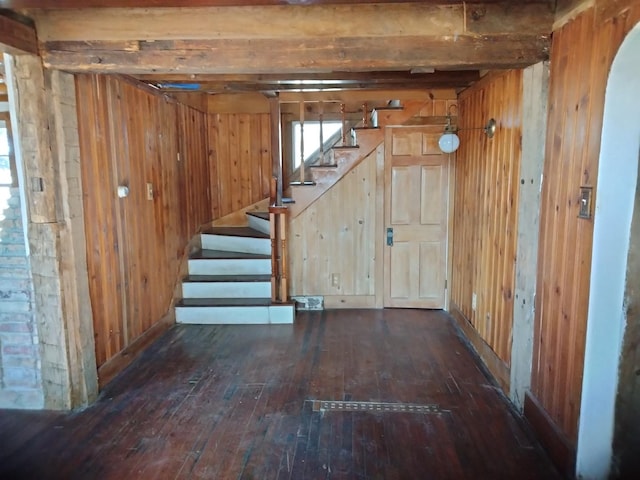 below grade area featuring hardwood / wood-style floors, stairway, arched walkways, and wood walls