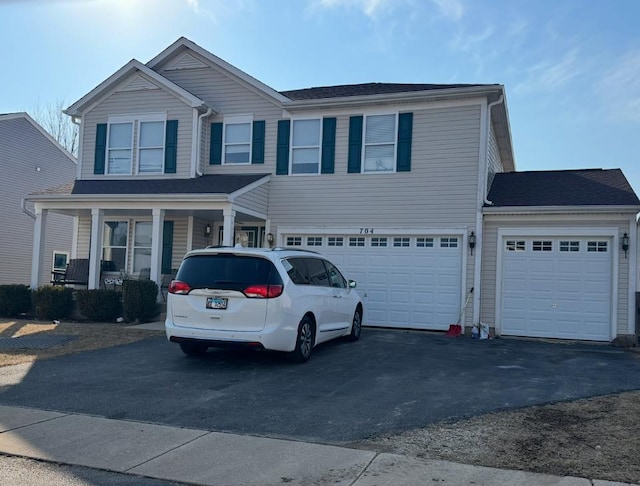 view of front facade with aphalt driveway, a porch, and an attached garage