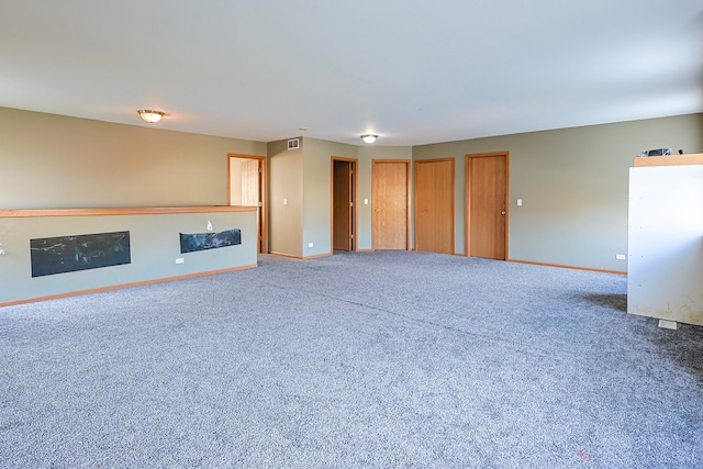 704 Doral Dr, Marengo, IL 60152 - unfurnished living room with visible vents, baseboards, and carpet