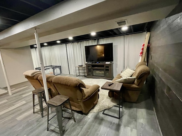 interior space with a fireplace, wood finished floors, and visible vents