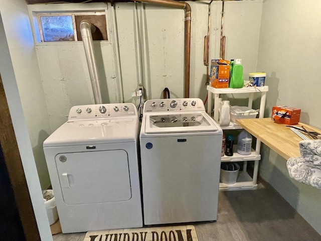 laundry area with laundry area, washer and clothes dryer, and wood finished floors