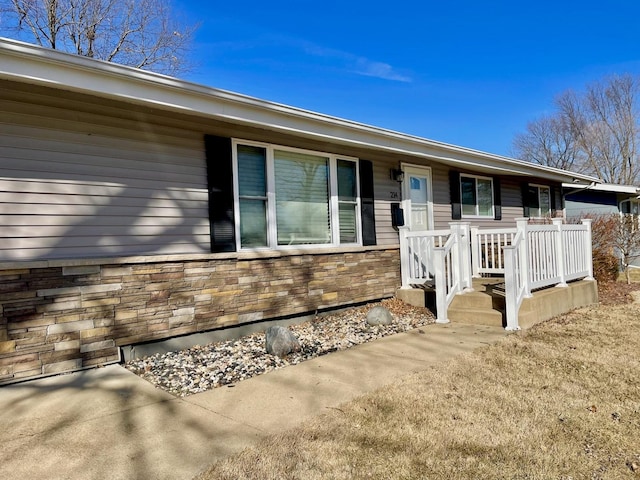 view of front of home featuring covered porch and stone siding