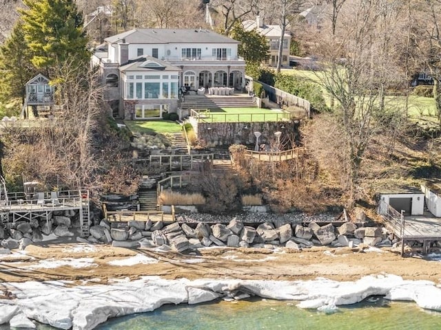 back of house with stairway, a balcony, and fence