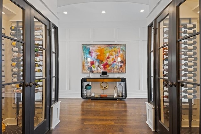 wine room with a decorative wall, recessed lighting, and wood finished floors