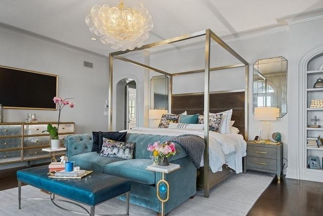 bedroom with wood finished floors, visible vents, an inviting chandelier, arched walkways, and ornamental molding