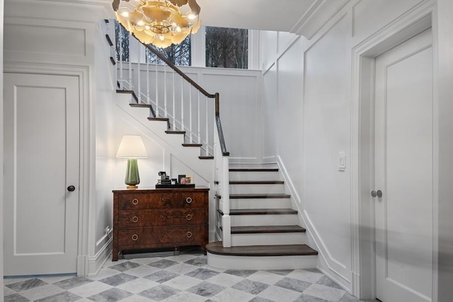 staircase with tile patterned floors and an inviting chandelier