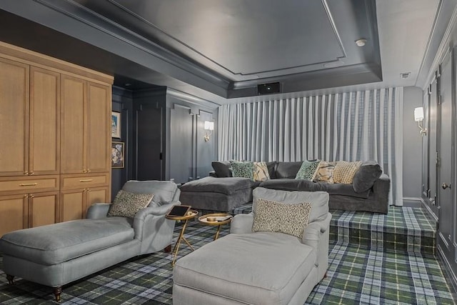 cinema with dark carpet, baseboards, crown molding, and a tray ceiling