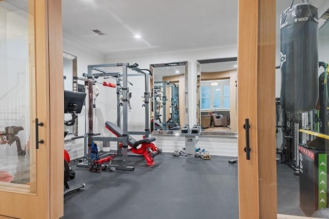 exercise room featuring visible vents and ornamental molding