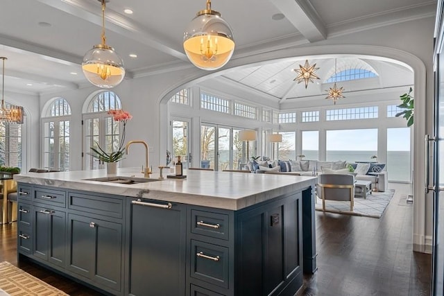 kitchen featuring dark wood finished floors, beam ceiling, open floor plan, and a sink