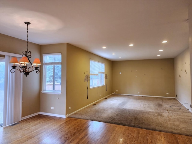 interior space with wood finished floors, visible vents, baseboards, recessed lighting, and a chandelier