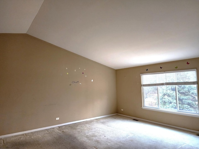 unfurnished room featuring lofted ceiling, baseboards, visible vents, and carpet floors