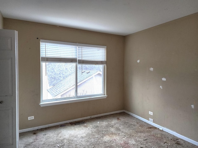 carpeted spare room with baseboards