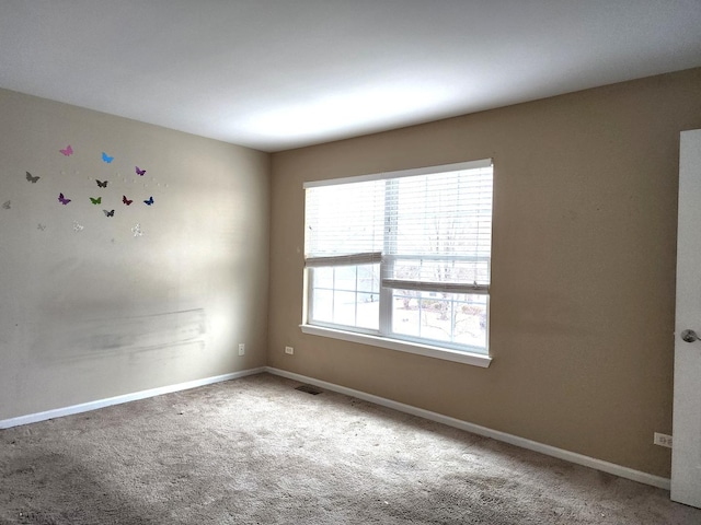 carpeted empty room with visible vents and baseboards