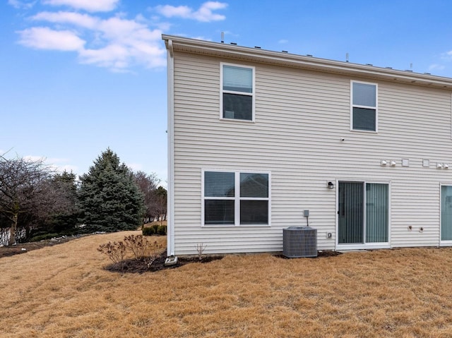 back of house with cooling unit and a yard