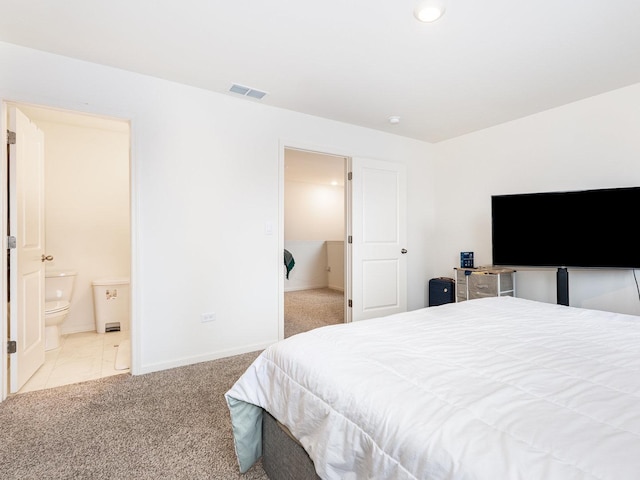 bedroom with ensuite bath, carpet, visible vents, and baseboards