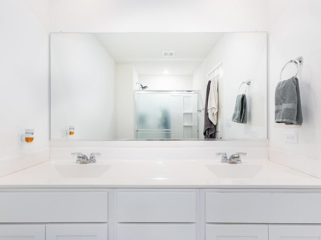 full bath with a shower stall and double vanity