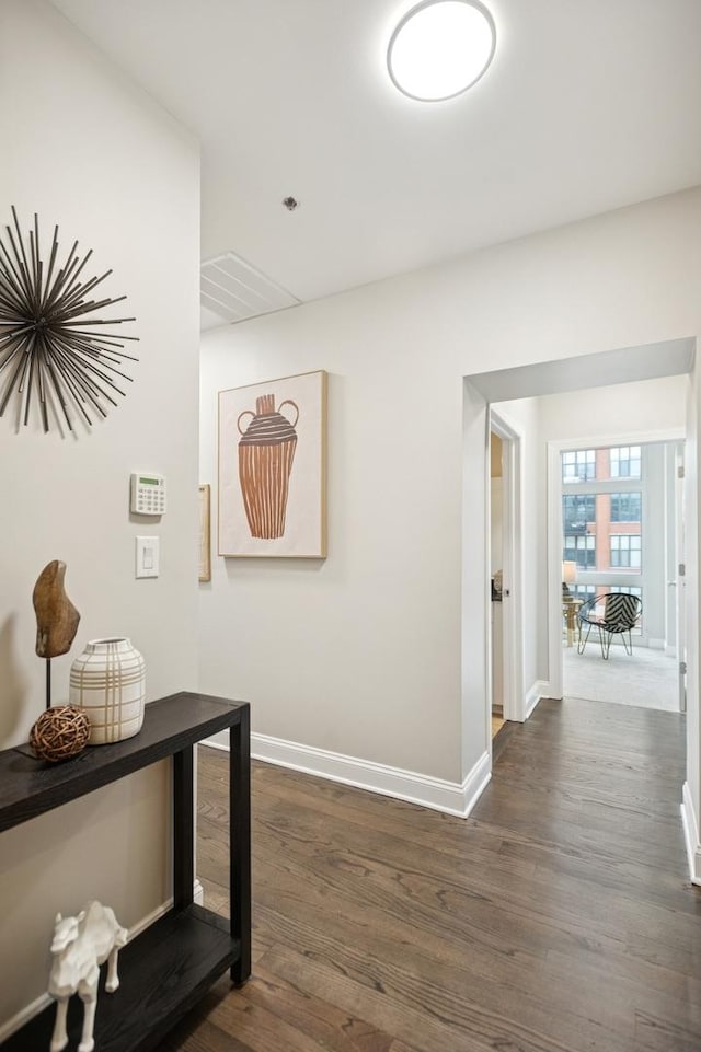 corridor featuring dark wood-style floors and baseboards