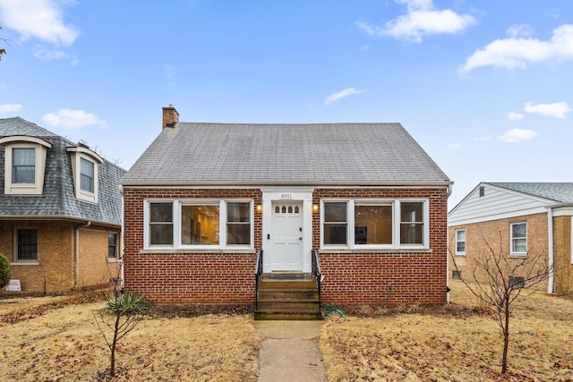 view of front of house with brick siding and a chimney