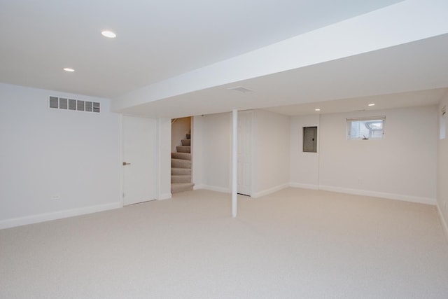 below grade area featuring electric panel, baseboards, visible vents, stairs, and recessed lighting