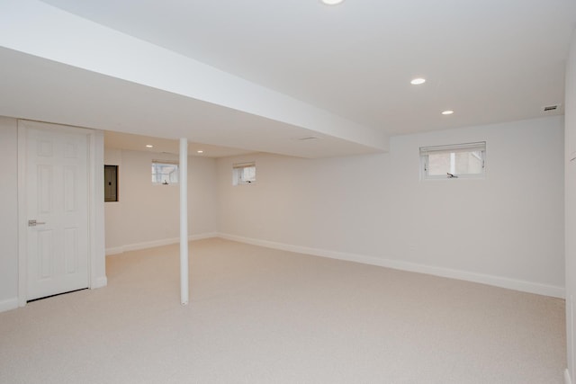 below grade area featuring light carpet, recessed lighting, electric panel, and baseboards