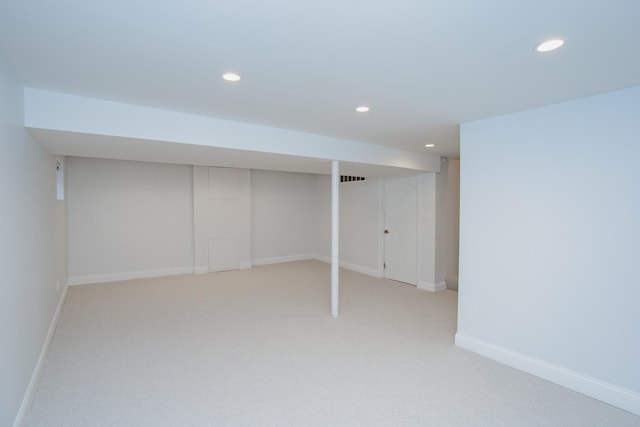 finished below grade area featuring light carpet, baseboards, and recessed lighting