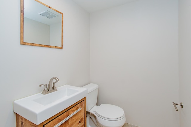 bathroom featuring toilet, visible vents, and vanity