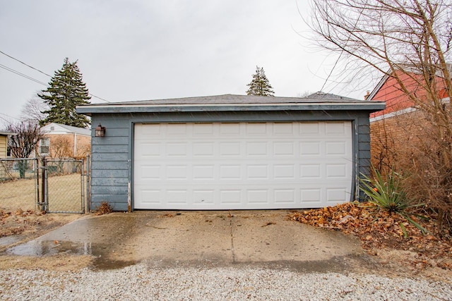 detached garage featuring fence and a gate