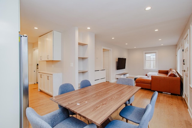 dining space with built in shelves, recessed lighting, and light wood-style flooring