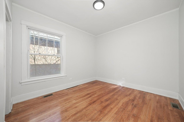 unfurnished room with visible vents, light wood-type flooring, crown molding, and baseboards