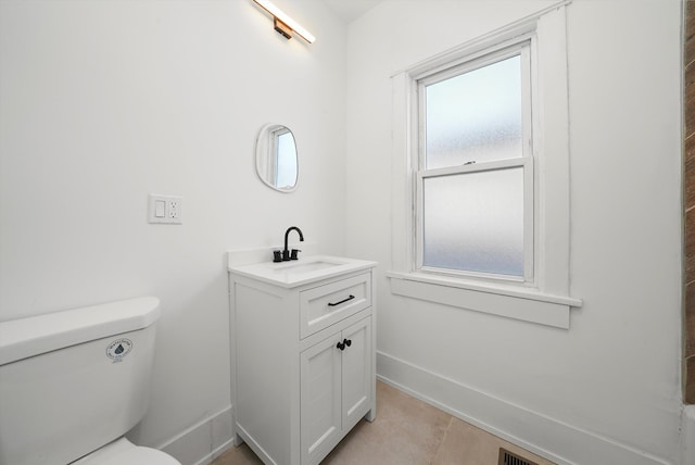 bathroom featuring vanity, toilet, baseboards, and tile patterned flooring