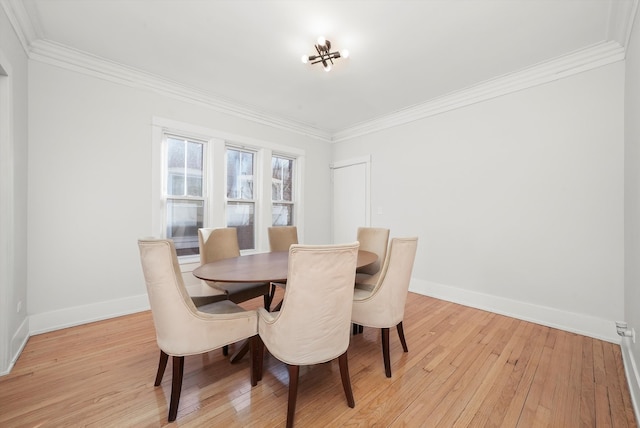 dining room with light wood-style flooring, baseboards, and ornamental molding