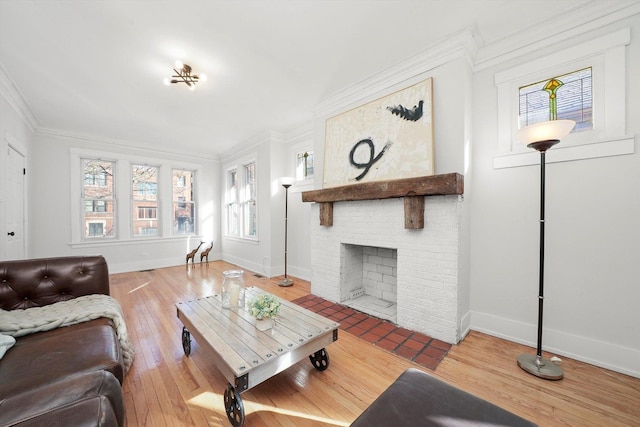 living area featuring a fireplace, crown molding, baseboards, and hardwood / wood-style flooring