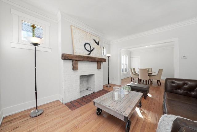 living area with ornamental molding, a fireplace, baseboards, and wood-type flooring