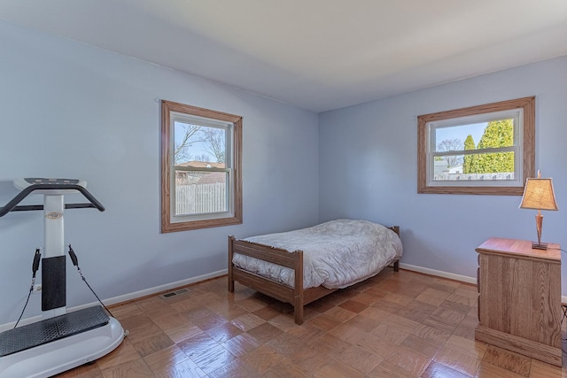 bedroom featuring baseboards and visible vents