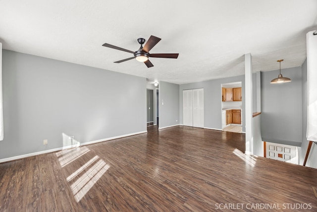 unfurnished living room featuring ceiling fan, baseboards, and wood finished floors