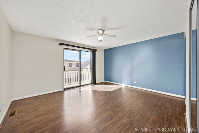 unfurnished room featuring baseboards, ceiling fan, visible vents, and wood finished floors