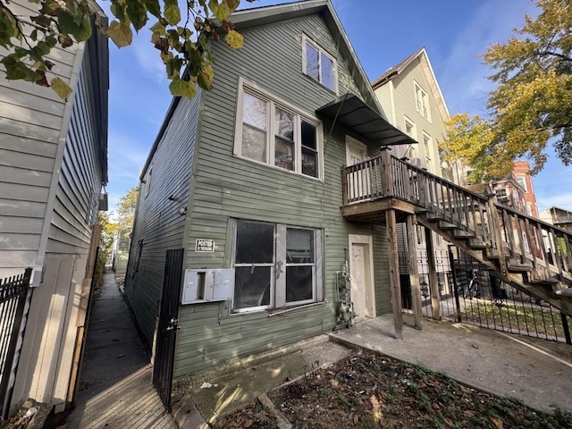 back of house with stairs, fence, and a patio