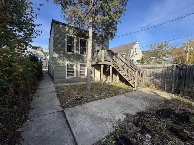 rear view of house with stairs and fence