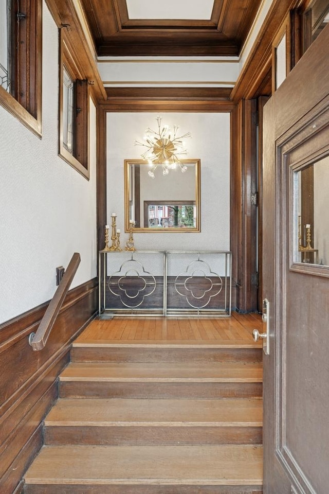 staircase with crown molding and wood finished floors