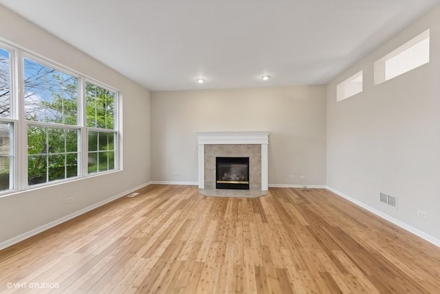 unfurnished living room featuring a fireplace, recessed lighting, visible vents, light wood-style floors, and baseboards