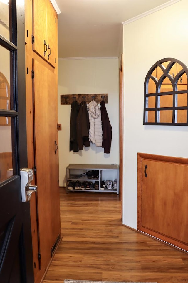 mudroom featuring ornamental molding and wood finished floors