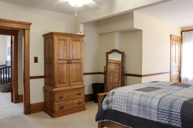 bedroom with light carpet, ceiling fan, and baseboards